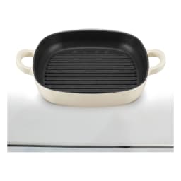 Square white and black cast iron grill pan with ribbed interior and two loop handles on a white background. - view 2