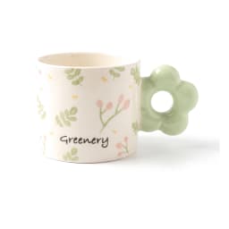 Off-white ceramic mug with green leaves, pink berries, 'Greenery' text, and a light green flower-shaped handle. - view 2