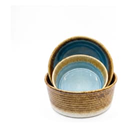 Round porcelain bowl with blue reactive glaze interior and brown and green textured exterior on a white background. - view 2