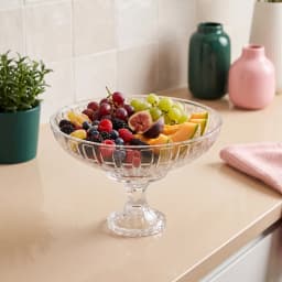 Clear glass fruit bowl with a textured pattern and a decorative pedestal base on a white background - view 5