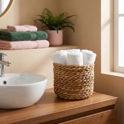 Set of three round natural light brown khous storage baskets of varying sizes on a white background. - view 7