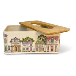 Rectangular cream metal tissue box with a colorful village illustration and a light brown wooden lid, on a white surface. - view 2