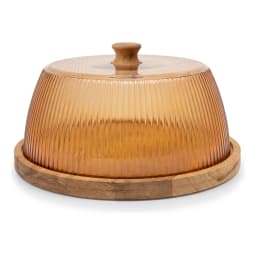 Round wooden base with a ribbed amber acrylic cake dome lid, displaying cheese, crackers, grapes, and figs on a kitchen coun… - view 3