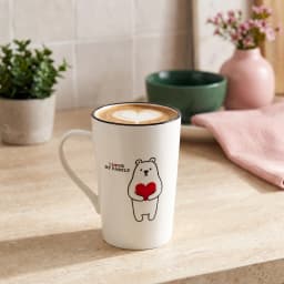 White ceramic mug with a black rim and a cartoon bear holding a red heart, text 'I LOVE MY FAMILY' on a white shelf. - view 1