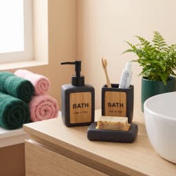 Three-piece black speckled ceramic bathroom set with light wood panels, including a soap dispenser, toothbrush holder, and s… - view 1