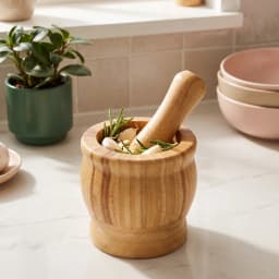 Light brown wooden mortar and pestle set on a white background, showing the natural wood grain and texture. - view 1