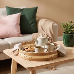 Set of three round natural light brown bamboo serving trays stacked, with perforated decorative rims on a white background. - view 1