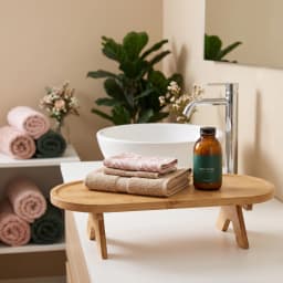 Natural wood oval stand with foldable legs, holding a cup of tea and a croissant on a bedside table. - view 1