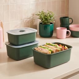 Three dark green rectangular plastic food storage containers with clear lids, stacked on a white background. - view 1