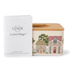 Rectangular cream metal tissue box with a colorful village illustration and a light brown wooden lid, on a white surface. - view 4