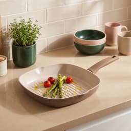 Square ceramic grill pan in beige and cream color, filled with grilled chicken skewers and vegetables on a kitchen counter. - view 4