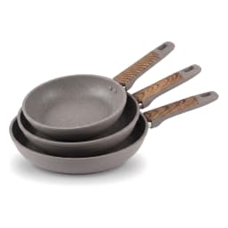Stack of three grey granite frying pans with speckled interiors and brown patterned, grey ergonomic handles on a white backg… - view 2