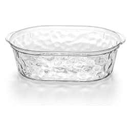 Single clear oval acrylic serving dish with a textured bottom, placed on a white shelf. - view 2