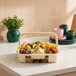 Light yellow plastic multi-compartment food storage box with clear lid and handle on a white background - view 1