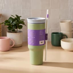 Light green stainless steel tumbler with a light grey 2-in-1 lid and a white straw, featuring purple accents. - view 1
