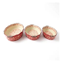 Set of three oval red porcelain baking dishes with cream interiors and red floral patterns, arranged on a white background. - view 3