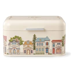 Cream metal bread box with a hinged lid, decorated with a colorful village scene illustration on a white background. - view 2