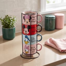 Four colorful ceramic mugs, pink, red, light blue, light pink, stacked on a black metal stand, each with a Disney character… - view 1