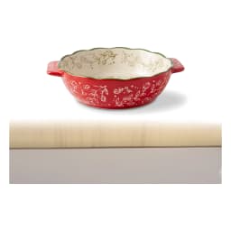 Set of three red granite oval baking dishes with white floral interior and green scalloped rim, shown on a kitchen counter. - view 7