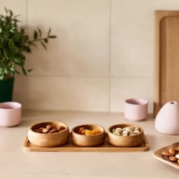 Three round light brown bamboo serving bowls on a rectangular bamboo tray against a white background - view 4