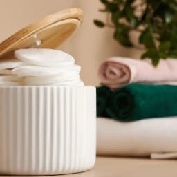 White ribbed porcelain storage jar with a wooden lid and scoop, filled with coffee beans on a kitchen counter. - view 5
