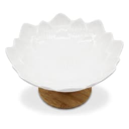 White porcelain serving bowl with a wavy, petal-like rim, sitting on a round light brown wood base, on a white background. - view 2