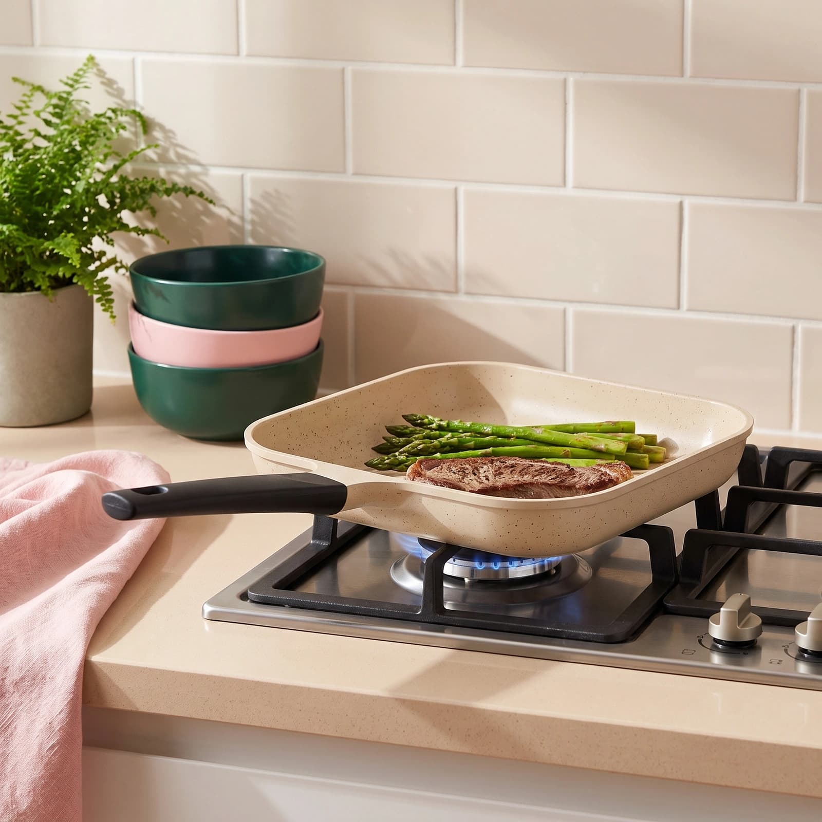 Dark grey square granite non-stick grill pan with a black handle, shown on its retail box.