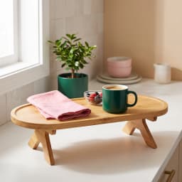 Natural wood oval stand with foldable legs, holding a cup of tea and a croissant on a bedside table. - view 3