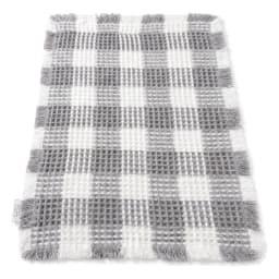 Rectangular grey and white checkered waffle-textured bath mat with fringed edges on a white background. - view 3