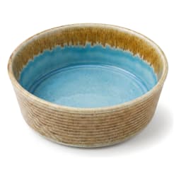 Round porcelain bowl with blue reactive glaze interior and brown and green textured exterior on a white background. - view 3