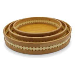 Set of three round natural light brown bamboo serving trays stacked, with perforated decorative rims on a white background. - view 4
