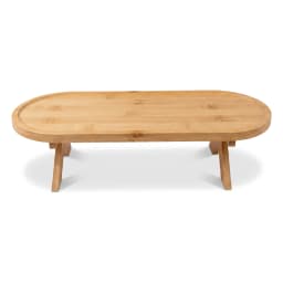 Natural wood oval stand with foldable legs, holding a cup of tea and a croissant on a bedside table. - view 2