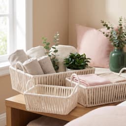 Three rectangular cream Khous storage baskets with handles, nested inside each other, on a shelf. - view 4