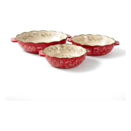 Set of three red granite oval baking dishes with white floral interior and green scalloped rim, shown on a kitchen counter. - view 4