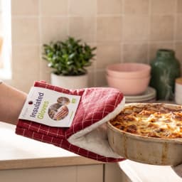 Single red and white quilted oven mitt with a grid pattern, folded, on a white background. - view 1
