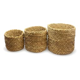 Set of three round natural light brown khous storage baskets of varying sizes on a white background. - view 4