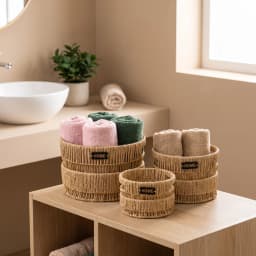 Set of three round natural khous woven storage baskets with 'HOME' tags, varying in size, on a white background. - view 4
