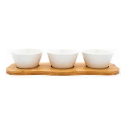 Three white porcelain serving bowls with embossed patterns on a light brown wooden tray, isolated on white. - view 4