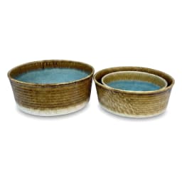 Round porcelain bowl with blue reactive glaze interior and brown and green textured exterior on a white background. - view 6