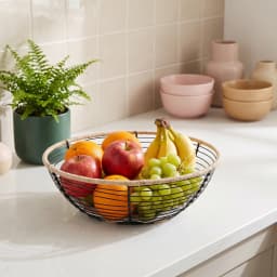 Round black stainless steel wire fruit basket with natural rope trim and a white checkered fabric liner on a white backgroun… - view 4