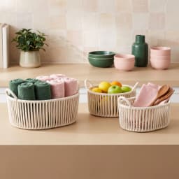 Three cream-colored oval khous nested storage baskets with integrated handles, stacked on a white background. - view 3