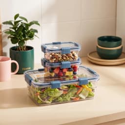 Three clear rectangular plastic food storage containers with blue clasps, stacked on top of each other on a white background. - view 1