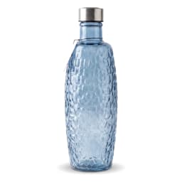 Tall blue glass bottle with a textured honeycomb pattern and a silver metallic cap, standing on a white shelf. - view 2