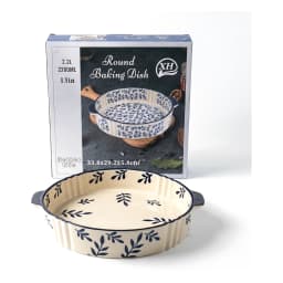 Round cream porcelain baking dish with dark blue leaf patterns and fluted edges, featuring two small handles on a white back… - view 3