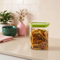 Single clear rectangular glass food storage container with a bright green airtight plastic lid on a white background. - view 3