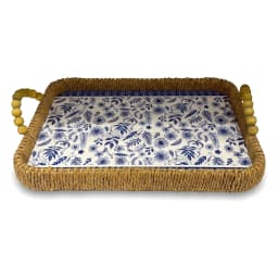 Two rectangular woven khous serving trays with blue floral plastic liners and wooden bead handles on a wooden coffee table. - view 3