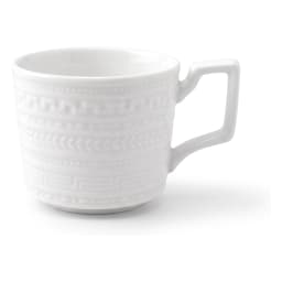 Cream ceramic mug with a textured pattern and square handle, filled with coffee, on a light countertop with a plant and bowl… - view 2