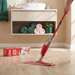 Red spray mop with a white microfiber pad, shown on its red and white product packaging box. - view 1