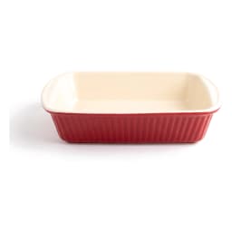 Single rectangular red porcelain loaf pan with ribbed exterior and cream interior on a white shelf - view 2