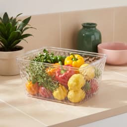 Clear rectangular acrylic storage basket with textured wavy sides, sitting on a white shelf. - view 1